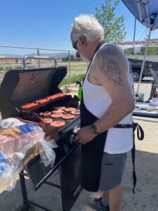 Richard Brown grilling burgers at Marvel Way sober living community BBQ